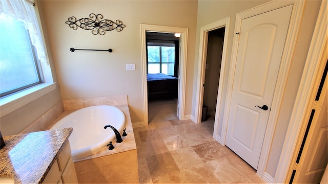 ensuite bathroom featuring ensuite bath, a garden tub, and vanity