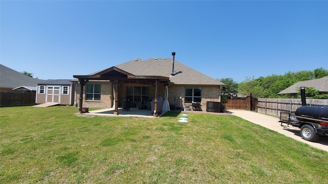 back of house with a patio area, an outbuilding, a shed, and a fenced backyard