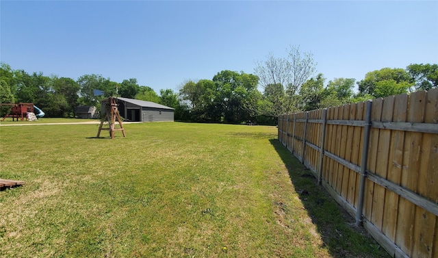 view of yard with fence and a playground