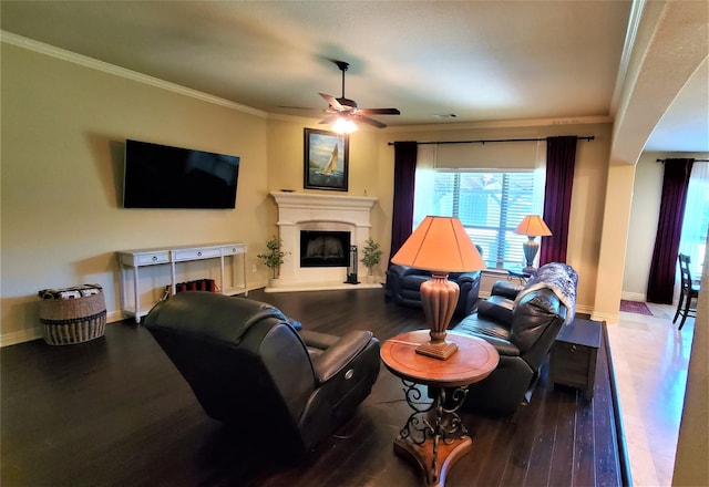 living room with crown molding, baseboards, a ceiling fan, and wood finished floors