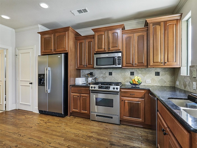 2500 Fountain Cv, Carrollton, TX 75006 - kitchen featuring visible vents, ornamental molding, dark wood-type flooring, a sink, and appliances with stainless steel finishes