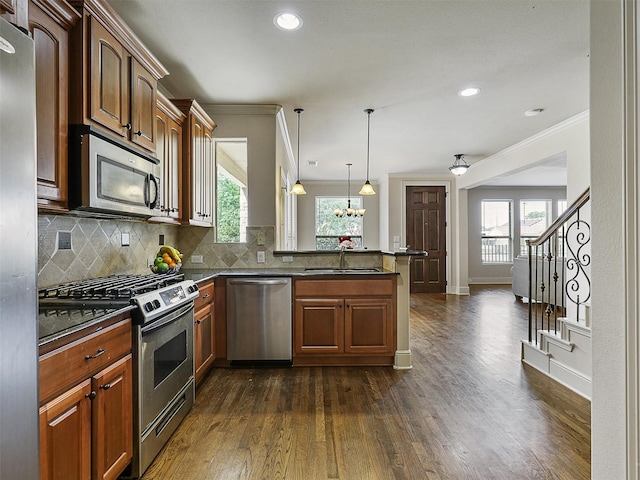 2500 Fountain Cv, Carrollton, TX 75006 - kitchen featuring ornamental molding, a peninsula, a sink, dark wood finished floors, and appliances with stainless steel finishes