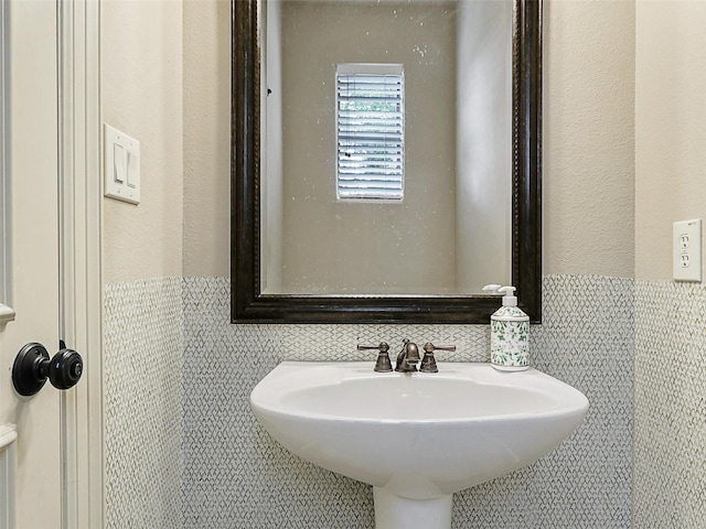 2500 Fountain Cv, Carrollton, TX 75006 - bathroom with a sink, a wainscoted wall, and tile walls