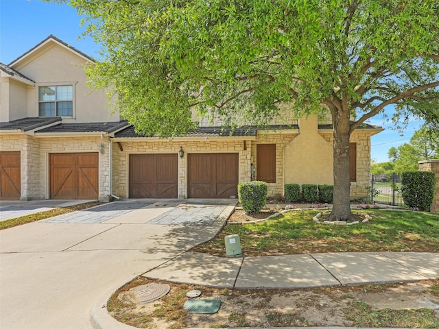 2500 Fountain Cv, Carrollton, TX 75006 - view of property with fence, stone siding, stucco siding, an attached garage, and driveway