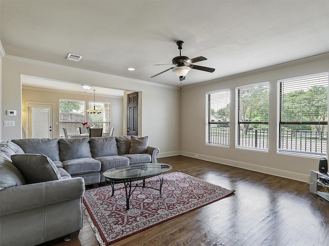 2500 Fountain Cv, Carrollton, TX 75006 - living area featuring visible vents, dark wood finished floors, baseboards, ceiling fan with notable chandelier, and ornamental molding