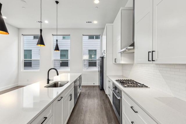 2912 Raleigh St Unit 102, Dallas, TX 75219 - kitchen with decorative backsplash, a sink, stainless steel appliances, dark wood-style flooring, and wall chimney exhaust hood