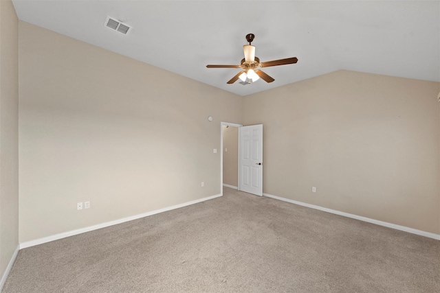 carpeted spare room with vaulted ceiling, visible vents, baseboards, and ceiling fan