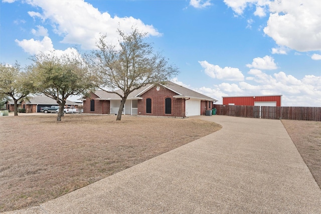 single story home with fence, brick siding, a garage, and concrete driveway