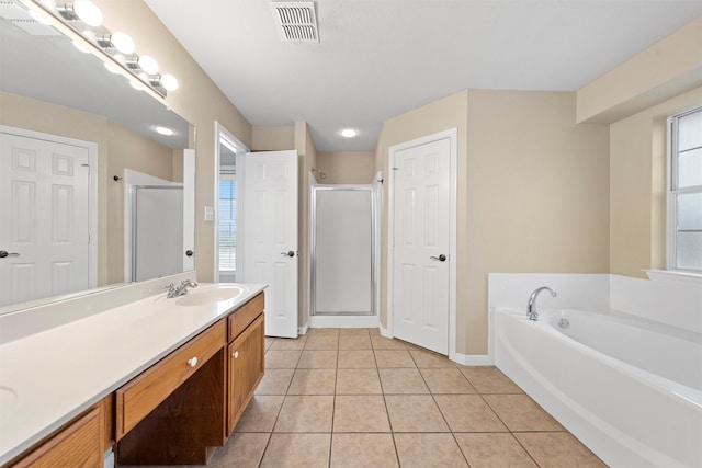 full bathroom featuring a stall shower, visible vents, tile patterned flooring, a garden tub, and vanity