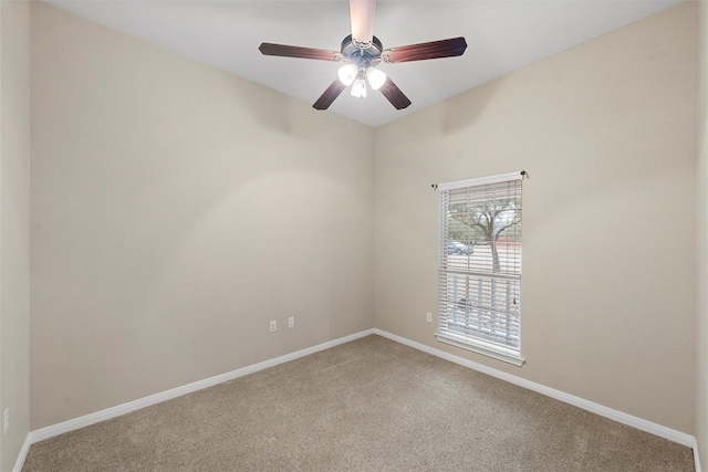 carpeted spare room featuring baseboards and ceiling fan