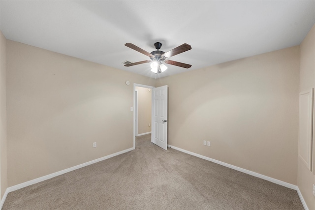 unfurnished room featuring baseboards, light colored carpet, and ceiling fan