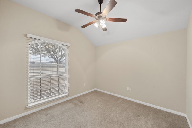 carpeted spare room featuring vaulted ceiling, a ceiling fan, and baseboards