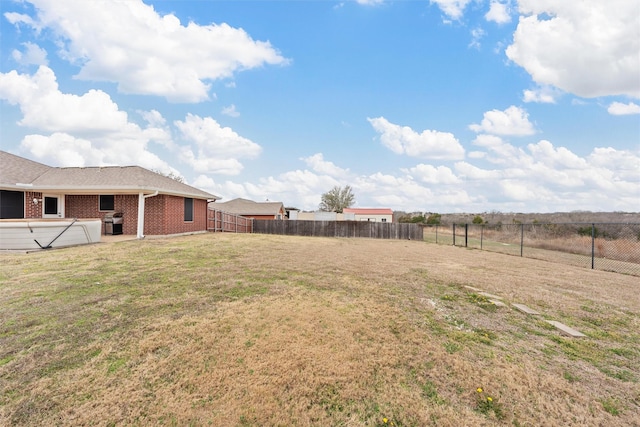 view of yard with a fenced backyard and a hot tub