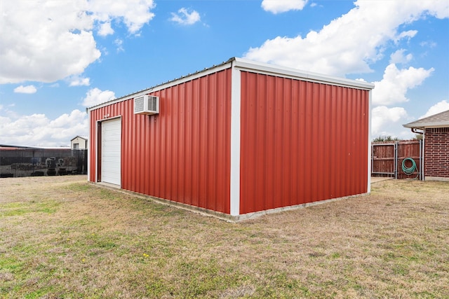 view of outdoor structure featuring an outbuilding, a wall unit AC, and fence
