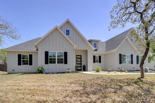 view of front of house with a front lawn, roof with shingles, and board and batten siding