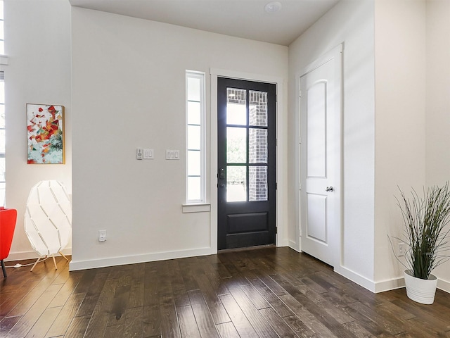 foyer featuring baseboards and dark wood-style flooring