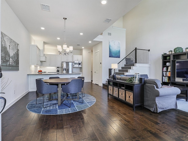 dining space featuring stairway, visible vents, dark wood-style floors, and an inviting chandelier