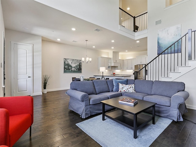 living room featuring baseboards, visible vents, a chandelier, and dark wood-style flooring