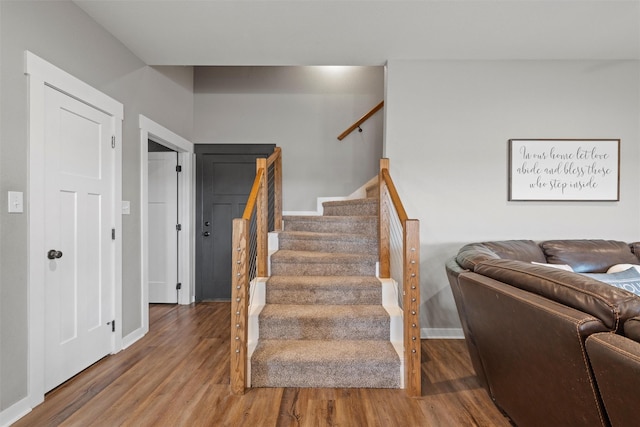 staircase with wood finished floors and baseboards