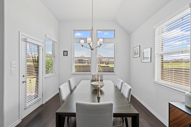 dining room featuring dark wood-style flooring, a notable chandelier, vaulted ceiling, and baseboards