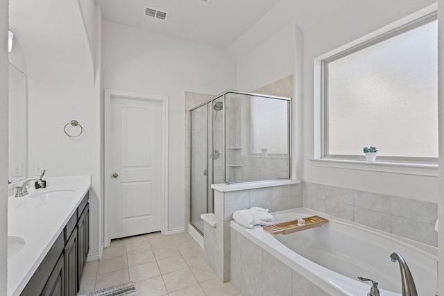 bathroom featuring tile patterned floors, double vanity, visible vents, a bath, and a stall shower