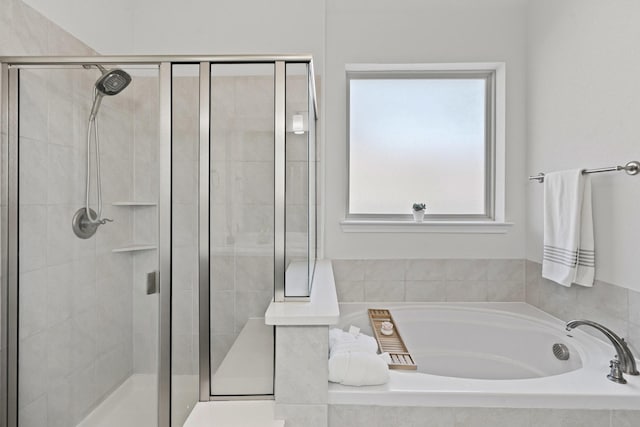 bathroom featuring a bath and a stall shower