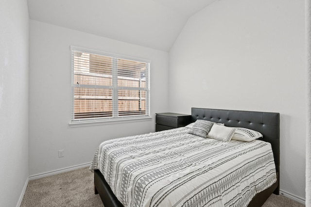 carpeted bedroom featuring vaulted ceiling and baseboards