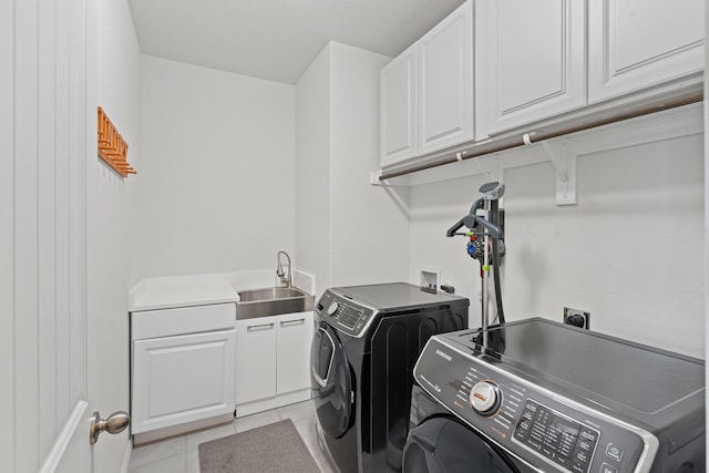 laundry area featuring separate washer and dryer, cabinet space, a sink, and light tile patterned floors