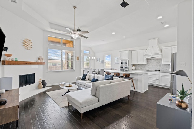 living area with recessed lighting, a fireplace with raised hearth, dark wood-style floors, and ceiling fan