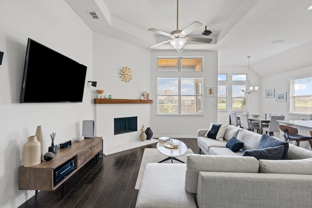 living room with a fireplace with flush hearth, visible vents, dark wood-type flooring, and ceiling fan with notable chandelier