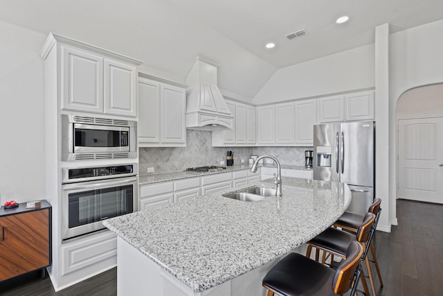 kitchen featuring a sink, stainless steel appliances, visible vents, white cabinets, and dark wood-style floors