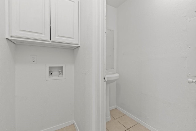 laundry room with cabinet space, hookup for a washing machine, baseboards, and light tile patterned floors