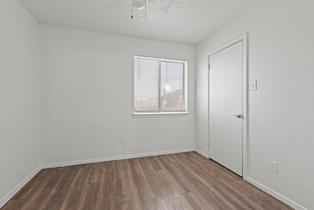 empty room with baseboards, a ceiling fan, wood finished floors, and a textured ceiling