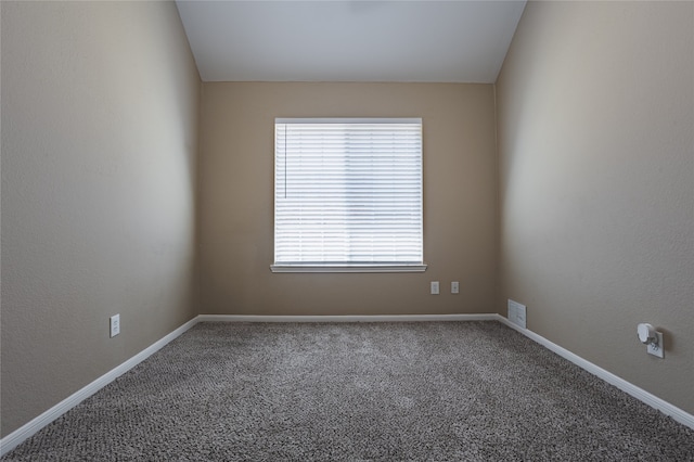 empty room featuring carpet and baseboards