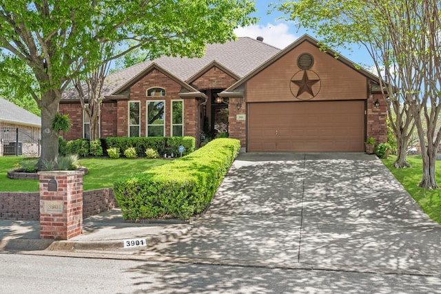 view of front facade featuring a front lawn, driveway, a shingled roof, a garage, and brick siding