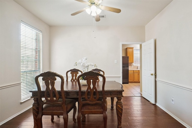 dining room featuring ceiling fan, baseboards, and wood-type flooring