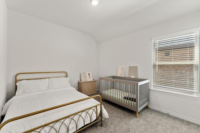 carpeted bedroom featuring lofted ceiling and baseboards
