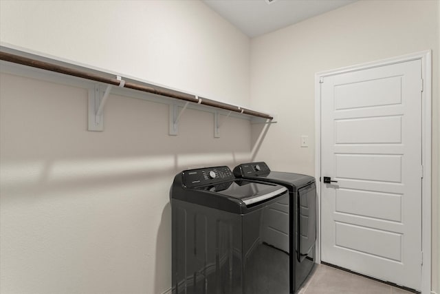 laundry area with washing machine and dryer, laundry area, and light tile patterned floors