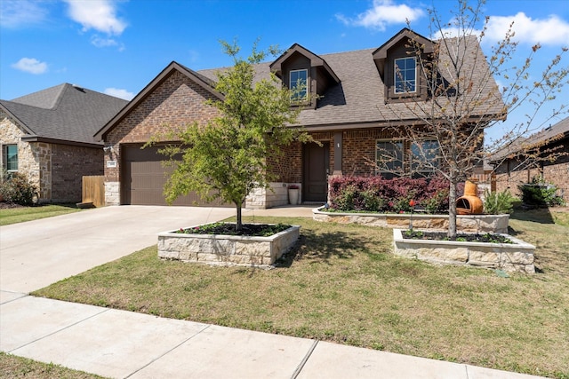 view of front of home featuring a garage, driveway, a shingled roof, a front yard, and brick siding