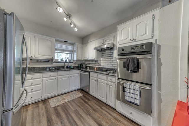 106 Guinevere Ct, Weatherford, TX 76086 - kitchen with dark wood-type flooring, under cabinet range hood, white cabinets, a sink, and appliances with stainless steel finishes