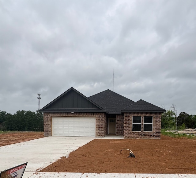 single story home with brick siding, driveway, and an attached garage