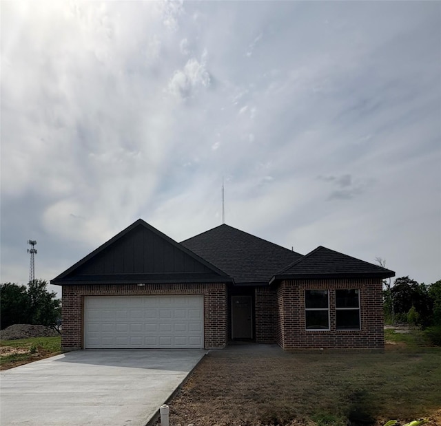 single story home with driveway, an attached garage, brick siding, and roof with shingles