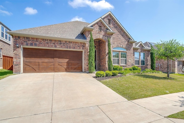 15024 Teasley Ave, Aledo, TX 76008 - view of front facade with a garage, a front yard, brick siding, a shingled roof, and driveway