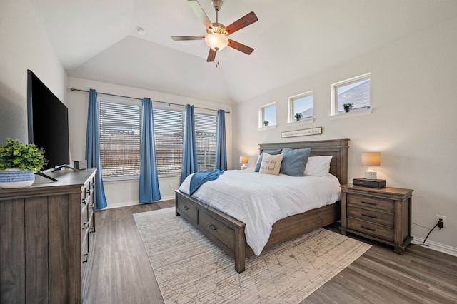 bedroom with vaulted ceiling, wood finished floors, baseboards, and ceiling fan