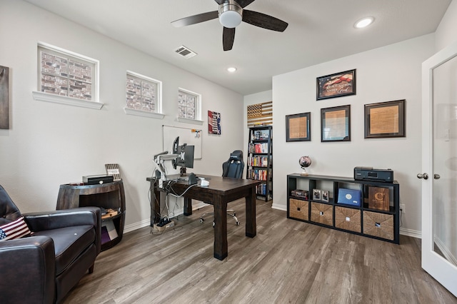 office space with wood finished floors, visible vents, baseboards, and ceiling fan