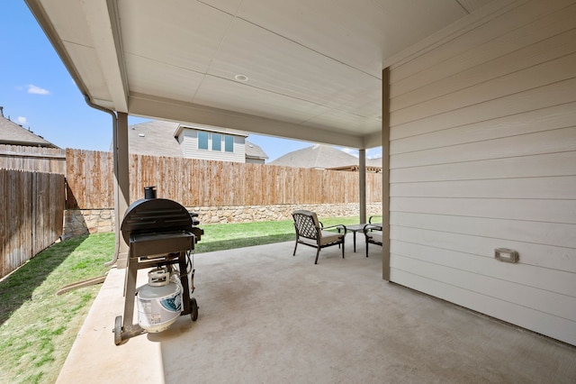 view of patio with grilling area and a fenced backyard