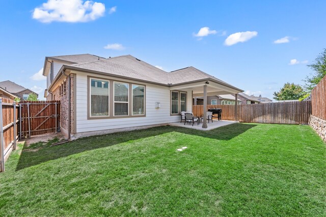rear view of house featuring a fenced backyard, a gate, a yard, and a patio area