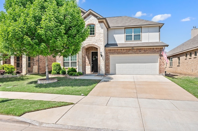 traditional home featuring a garage, driveway, a shingled roof, a front yard, and stucco siding