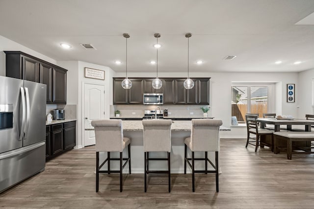 kitchen with backsplash, appliances with stainless steel finishes, and visible vents