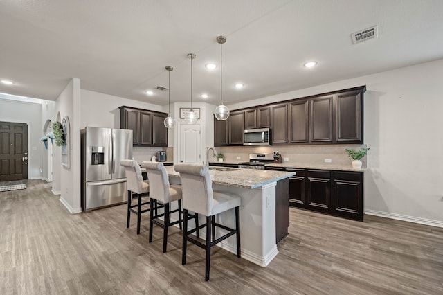 kitchen featuring a sink, dark brown cabinets, visible vents, wood finished floors, and appliances with stainless steel finishes